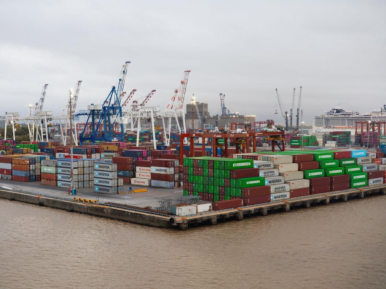 A container port with stacked cargo and cranes along the quay