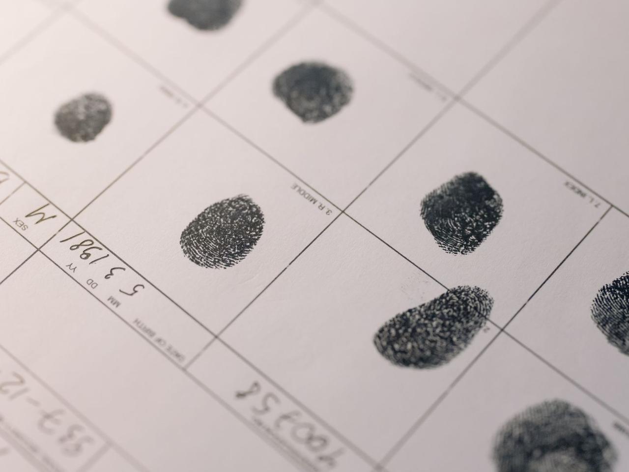 A fingerprint record card with inked prints and case notes